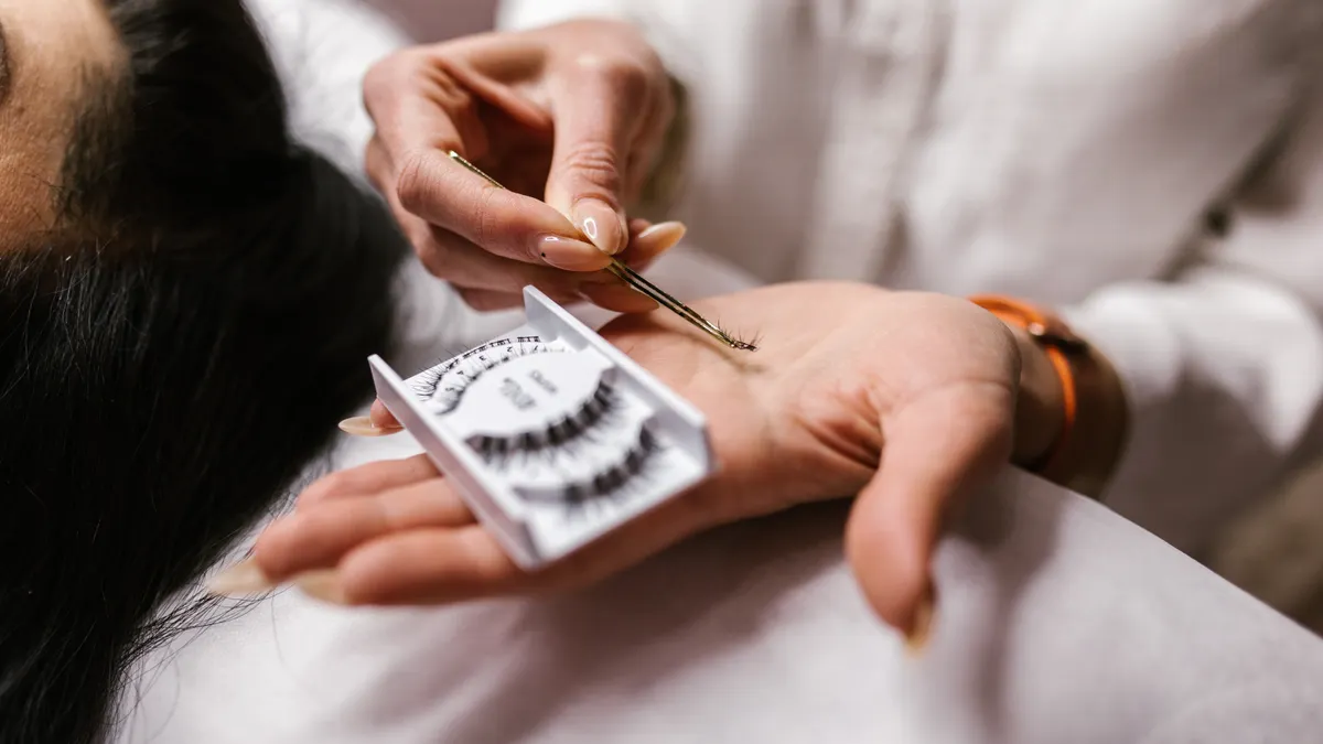 Lash tray and tweezers over a client during extension application