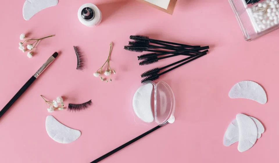 Flat lay of lash extensions, eye pads, and beauty tools