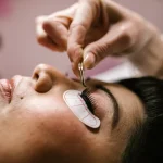 Technician applying eyelash extensions to a client's eye