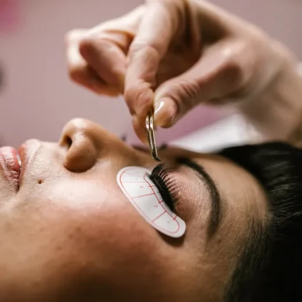 Technician applying eyelash extensions to a client's eye