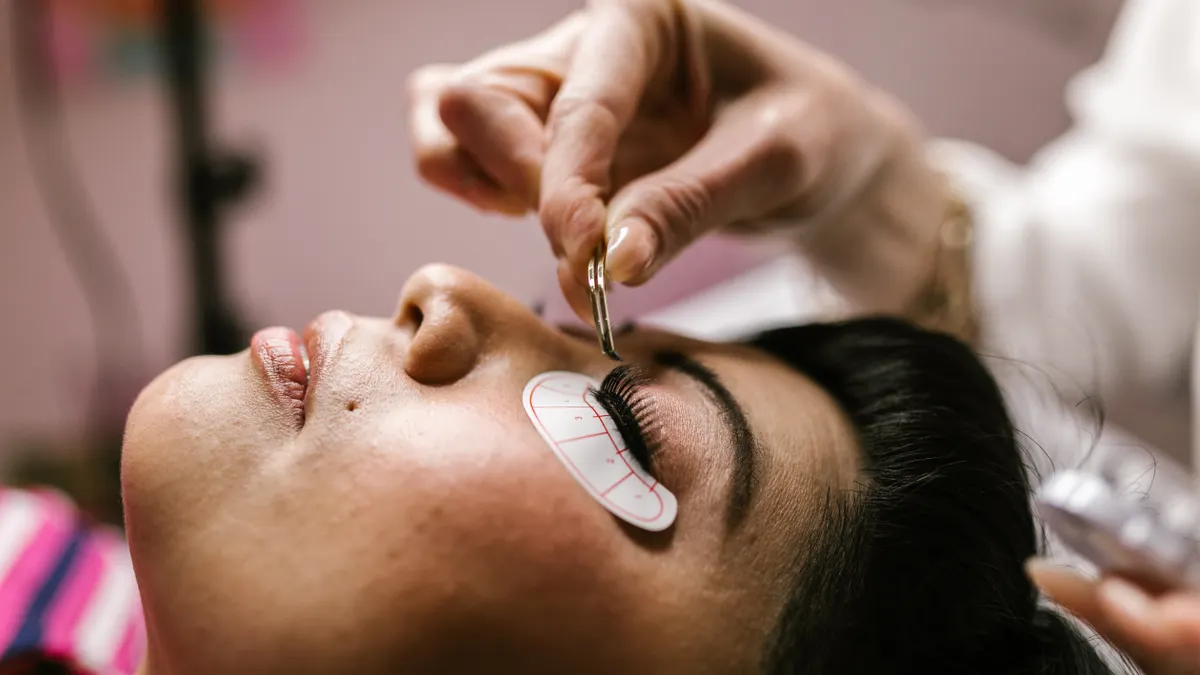 How to Choose Eyelash Extension Length, Curl, and Thickness Client receiving eyelash extension treatment
