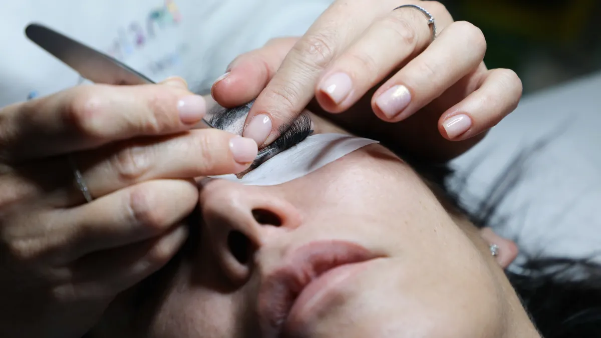 Technician applying false eyelashes to a client's eye
